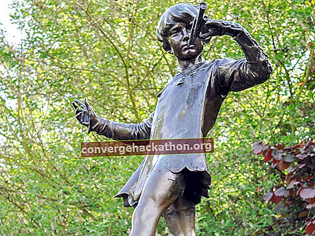 A estátua de Peter Pan em Kensington Gardens.  A estátua mostra o menino que nunca cresceria, soprando sua trompa no toco de uma árvore com uma fada, Londres.  conto de fadas