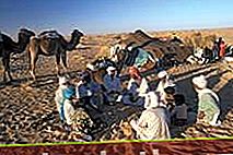 Семейство бедуини, седнало пред палатката си в пустинята Сахара.